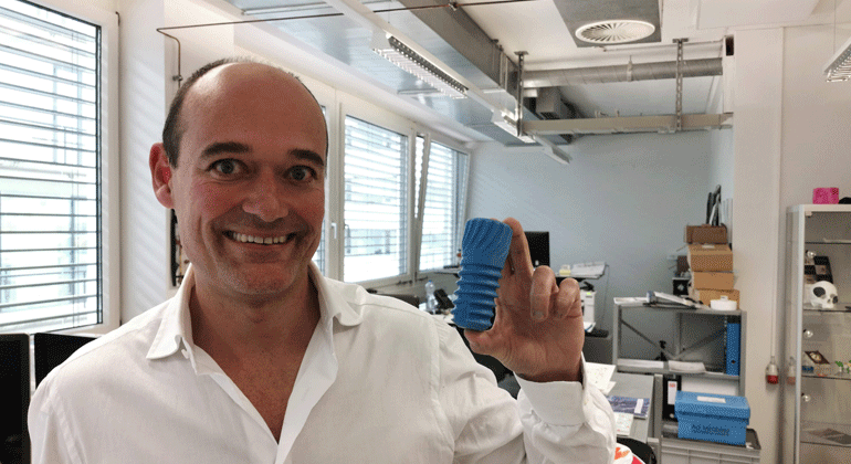 Stefan Stübinger shows a model of the dental implant. Photo: IPI