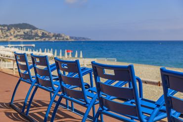 Des chaises bleues sur la promenade de Nice