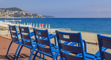 Des chaises bleues sur la promenade de Nice